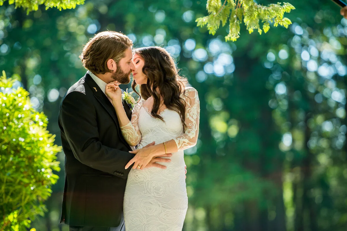 Bride and groom kiss with nature backdrop