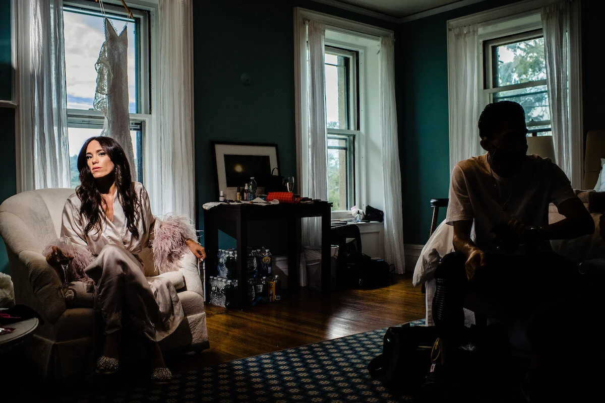 Bride sits in bridal suite with dramatic lighting