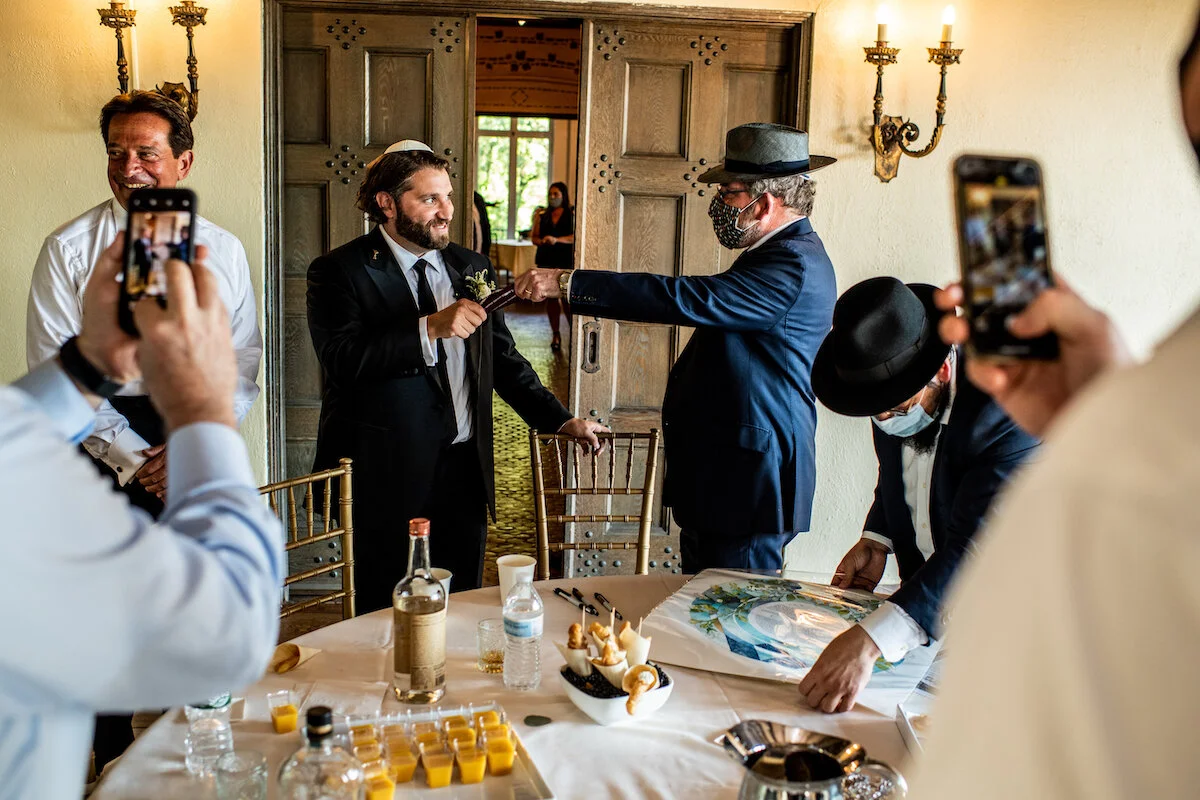 Husband to be shares a moment with family as groomsmen take pictures