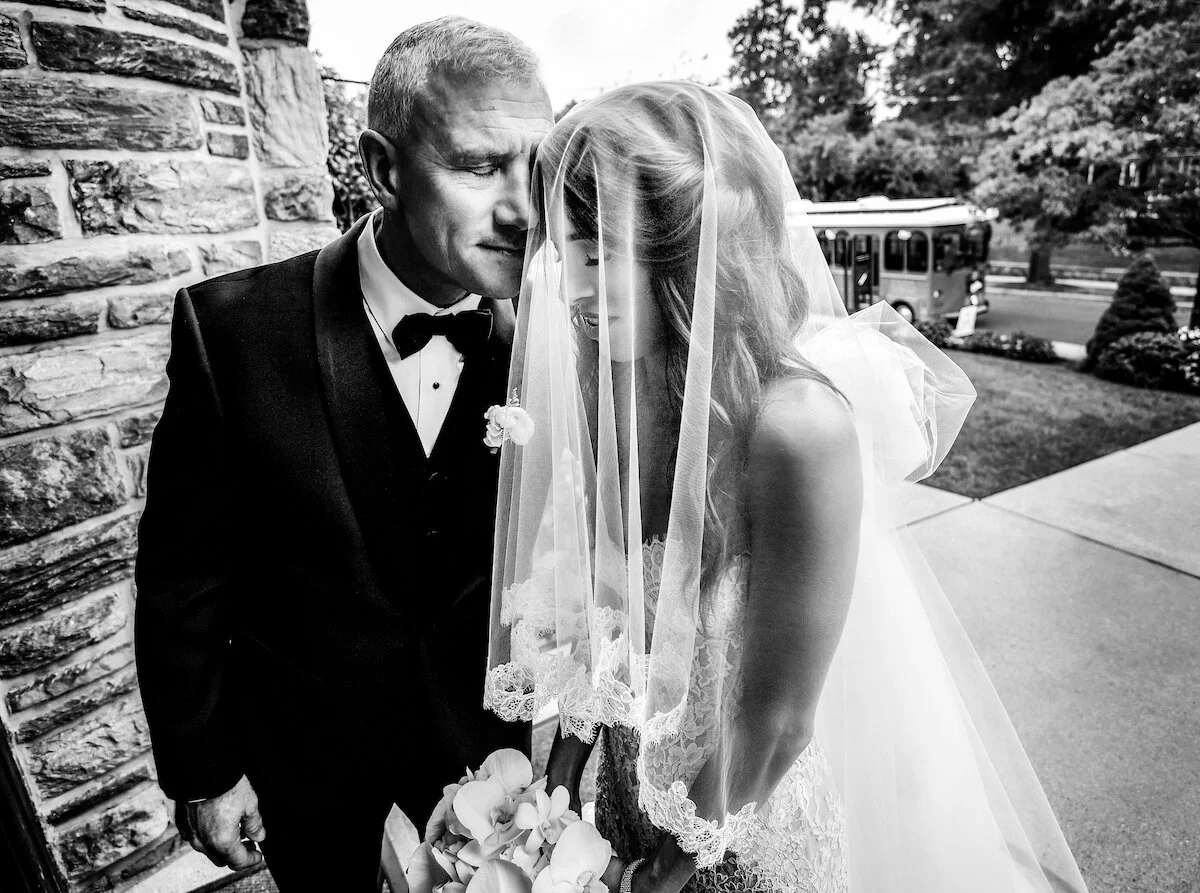 Father of the bride and bride embrace before walk down the aisle