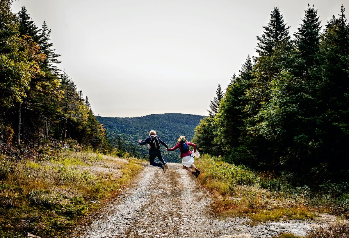 Bride and groom jump for joy on hike after getting married