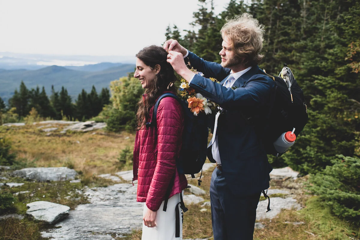 Groom fixes bride's hair with mountains in background