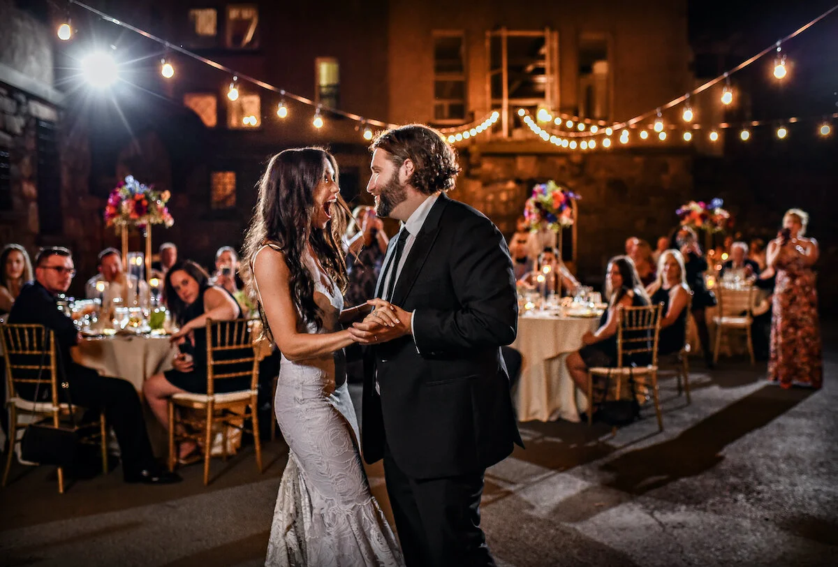 Bride and groom share first dance as guests watch