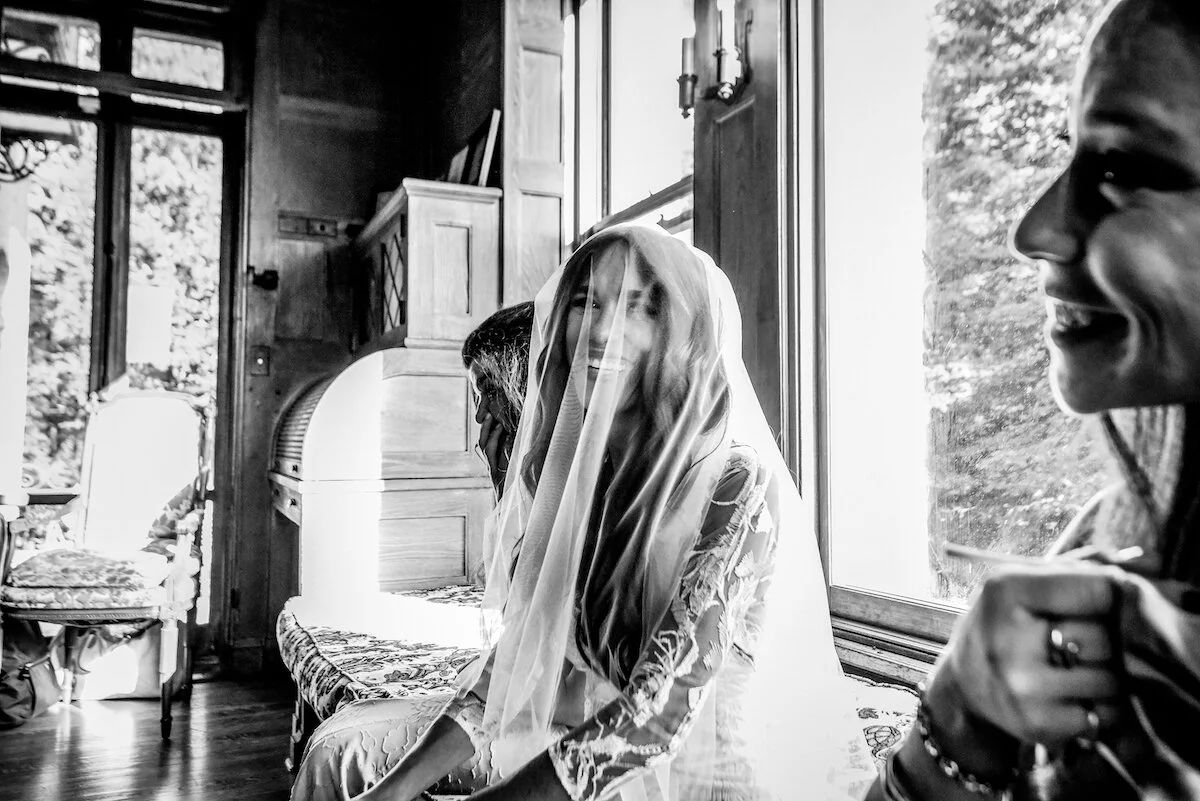 Smiling bride with veil sits in bridal suite