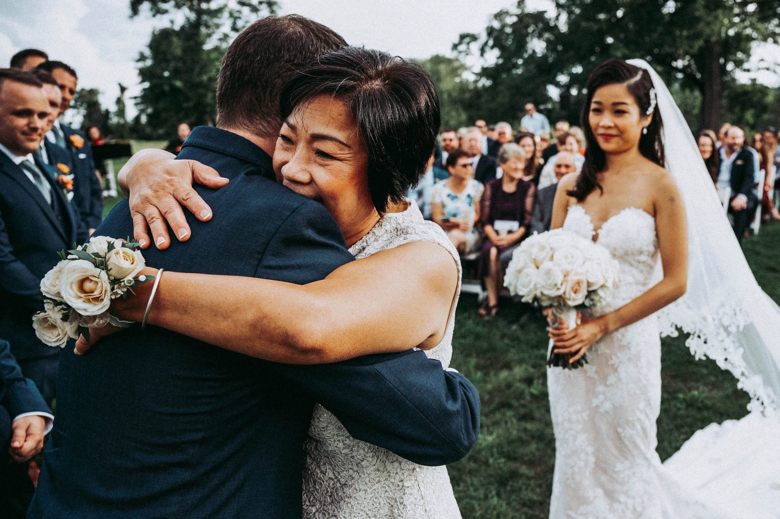 Mother of bride hugs groom