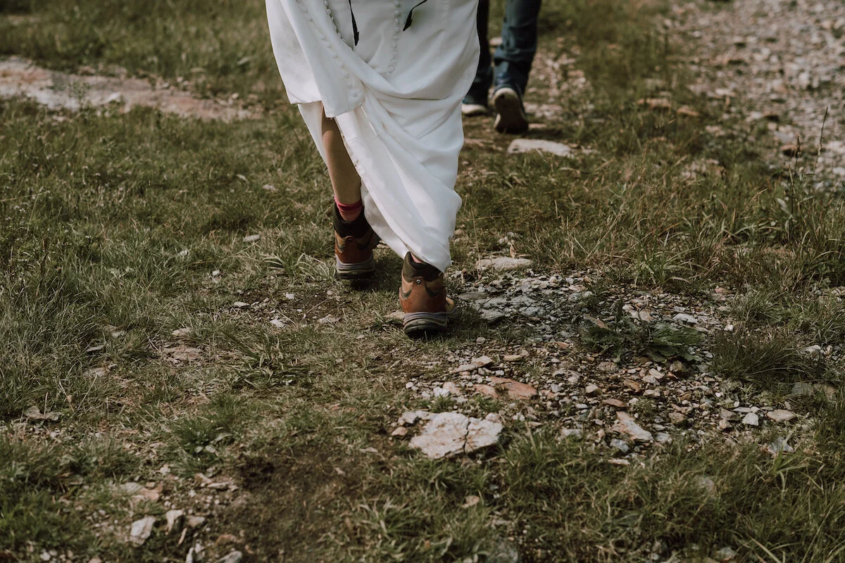 View of bride and grooms feet walking up mountain