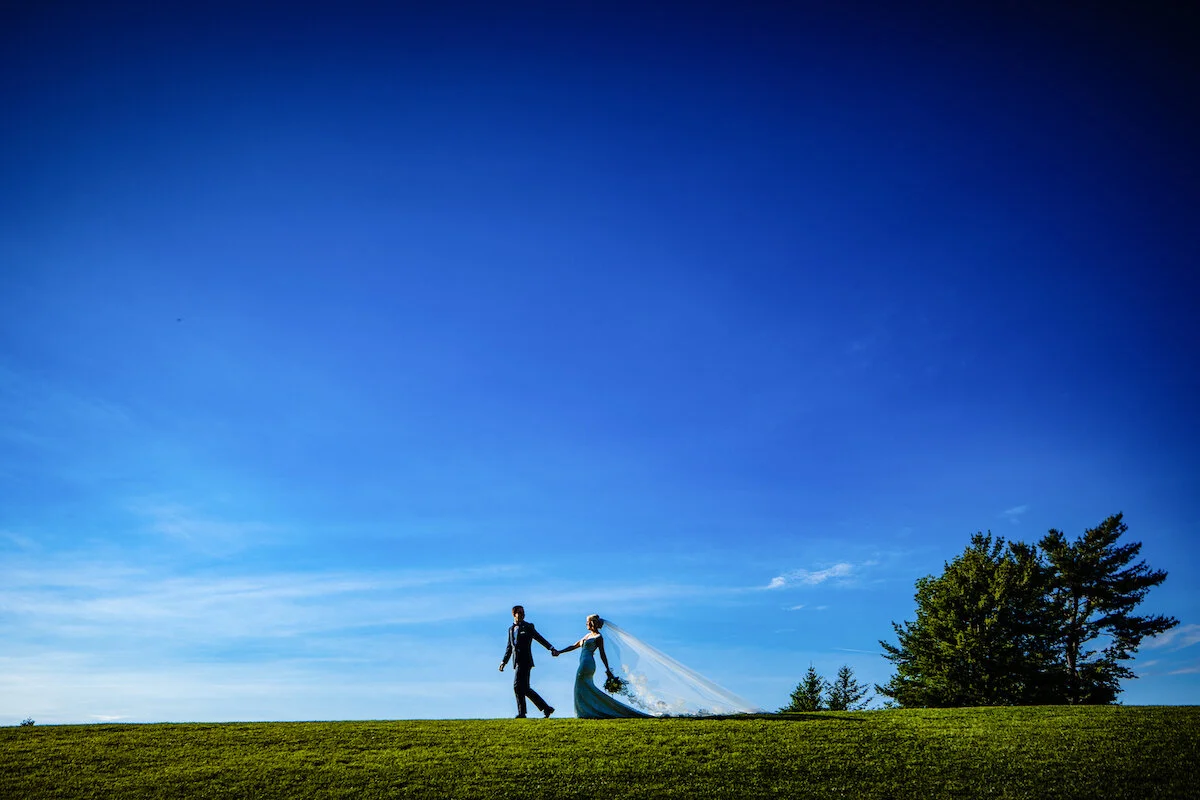 Shadow of bride and groom walking with blue skies in focus