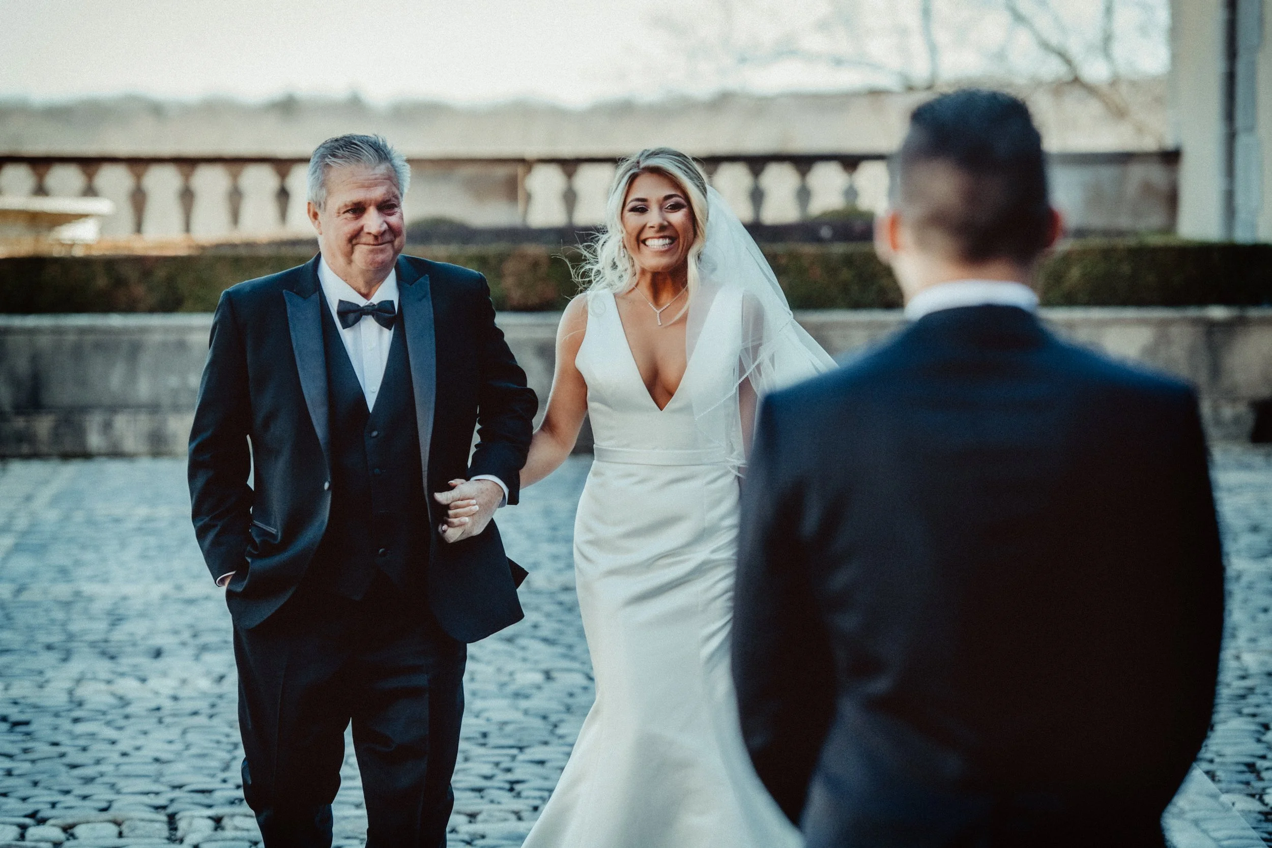 Father of the bride walks bride toward her groom