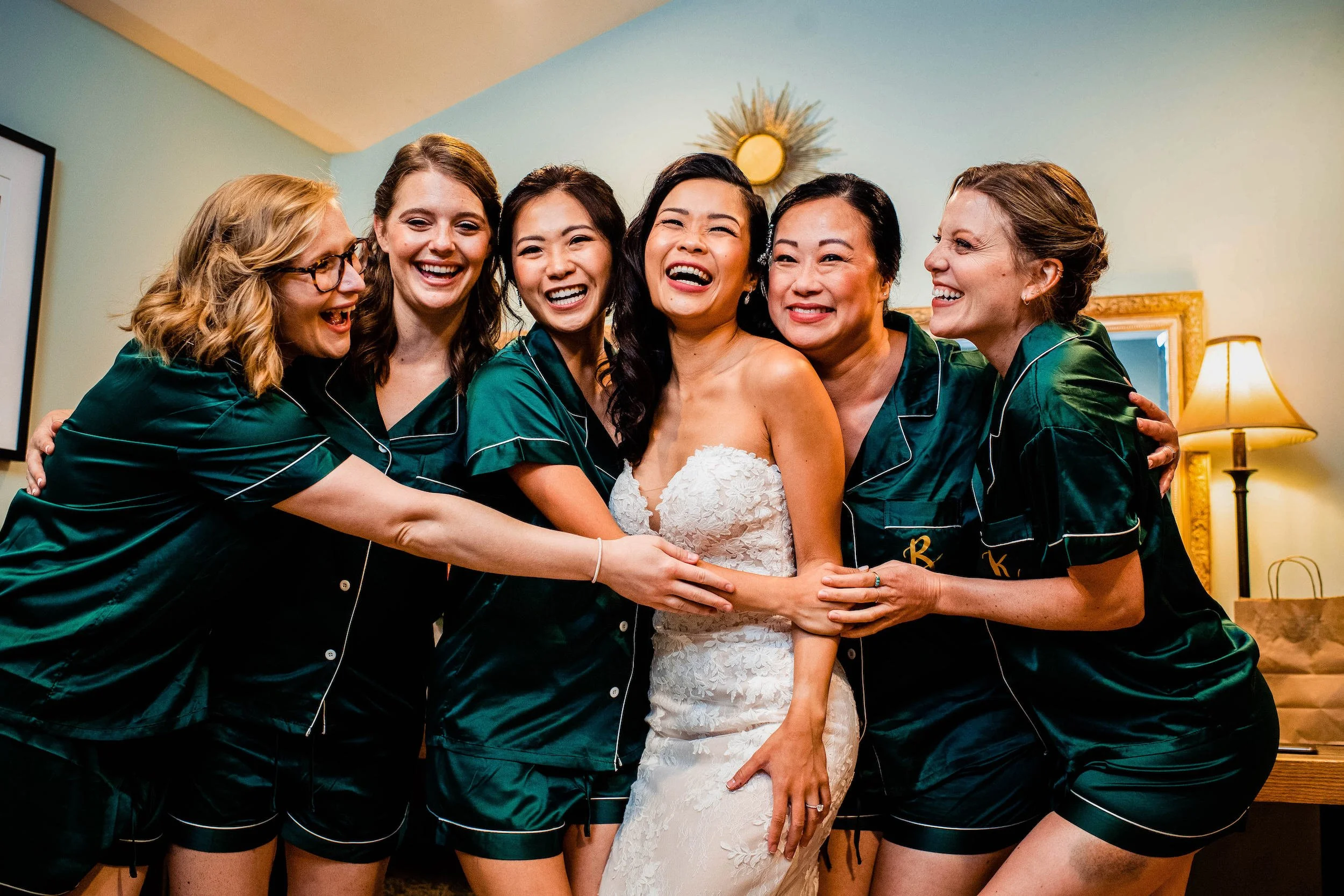 Bride and bridesmaids embrace before wedding ceremony