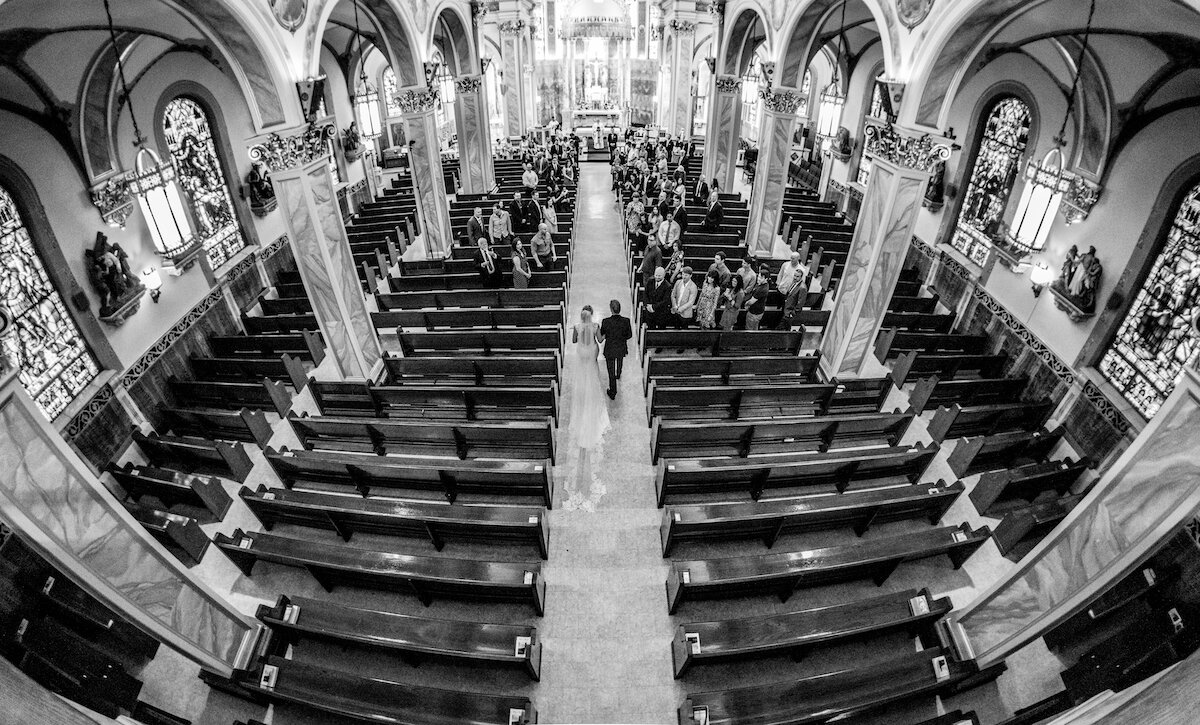 Bride and groom walk down church aisle