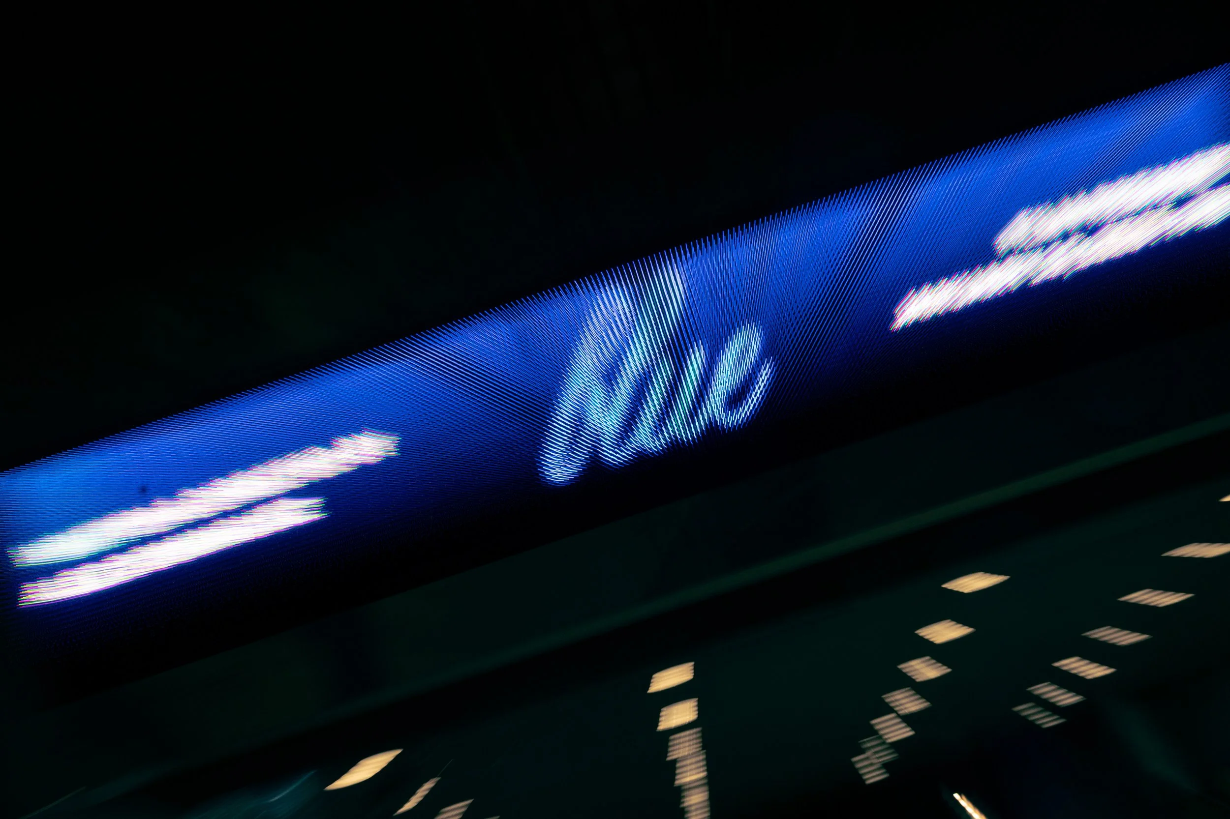 New York City Movie Premiere. New York event photographer. Close-up of an airport electronic departure board displaying the word 'title' with illuminated text and blurred background lights.