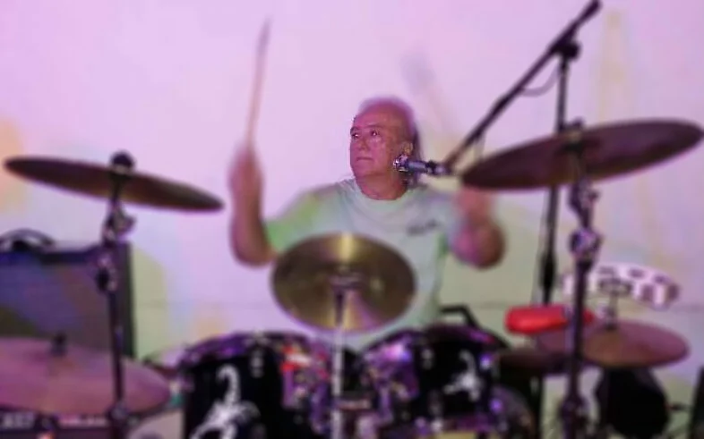 David playing drums in a stage setting.