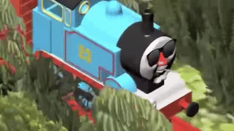 Thomas the train engine moves along a train track with sunglasses on.