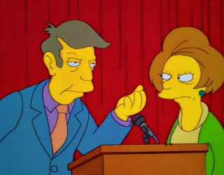 Professor Skinner from The Simpsons standing at a podium and rubbing his fingers together in front of another person. The symbol inferring, "money."