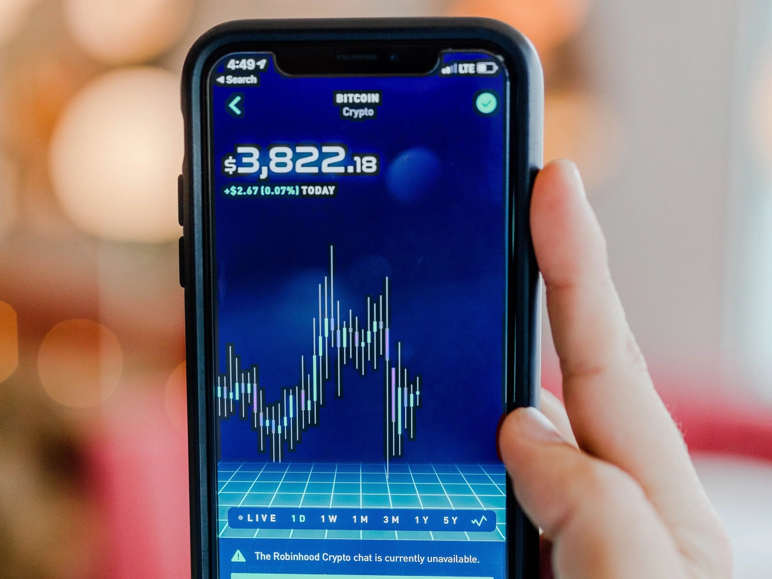 A smart phone displays bitcoin trajectory on Robin Hood trading app.