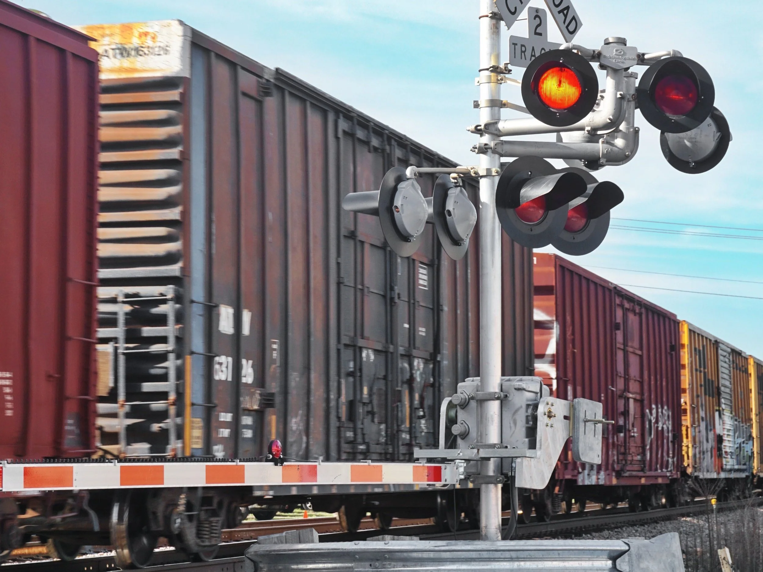 RED TRAIN CROSSES OVER TRAIN TRACKS.