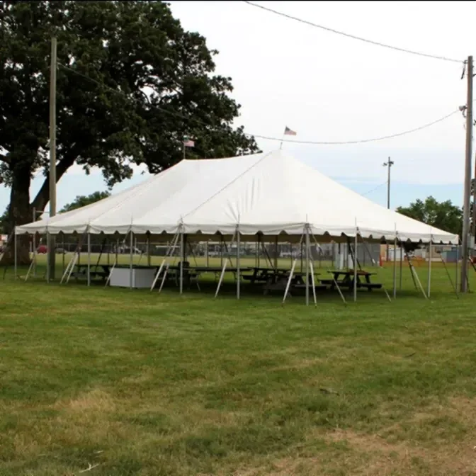 30x40 pole tent with picnic-style seating for casual wedding reception