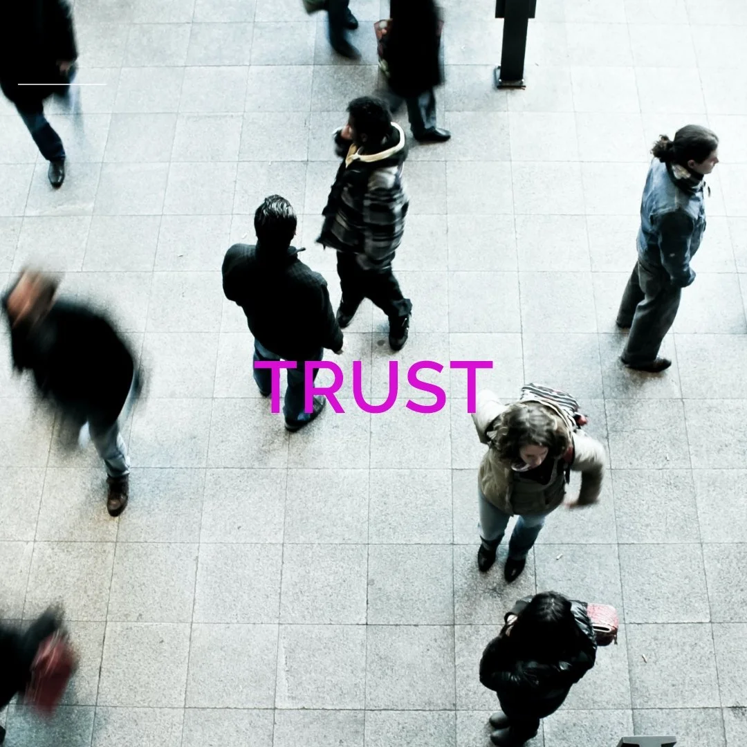 People walking in a courtyard with the word "TRUST" overlaid on top