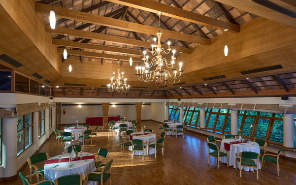 Spacious Sri Lankan wellness retreat dining and event hall with timber architecture, elegant chandeliers, and serene gathering spaces.
