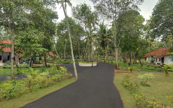 Scenic pathway through a tranquil Sri Lankan Ayurvedic retreat with tropical trees, private cottages, and landscaped wellness grounds.