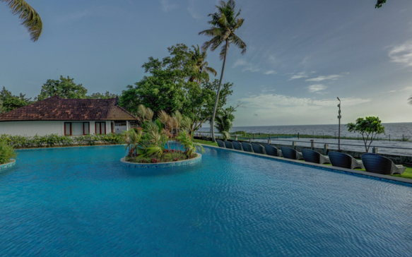 Spacious oceanfront pool at a Sri Lankan wellness resort with palm trees, tropical gardens, and peaceful sea views designed for restorative luxury.