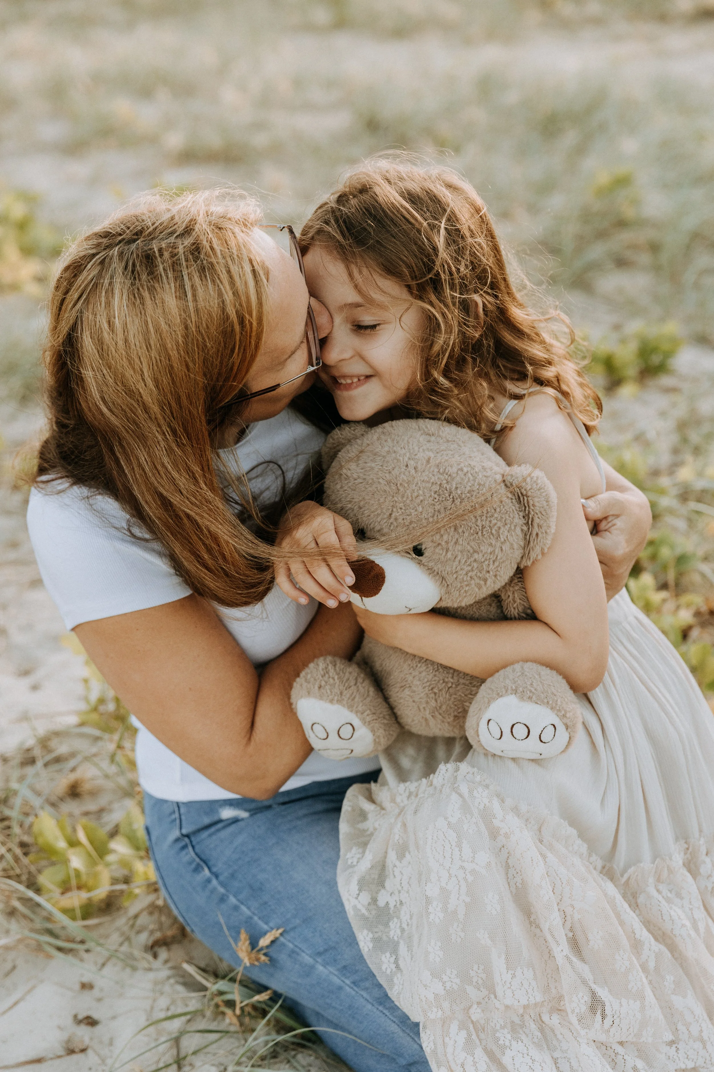 mum and daughter cuddle with teddy