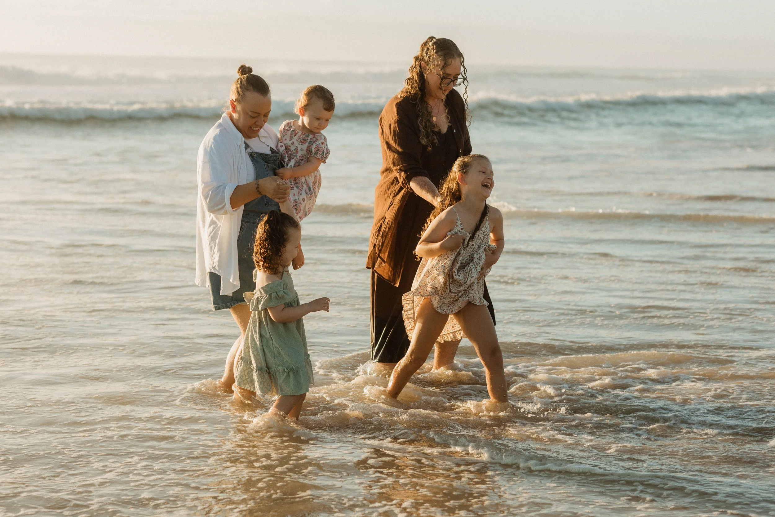 family plays in ocean
