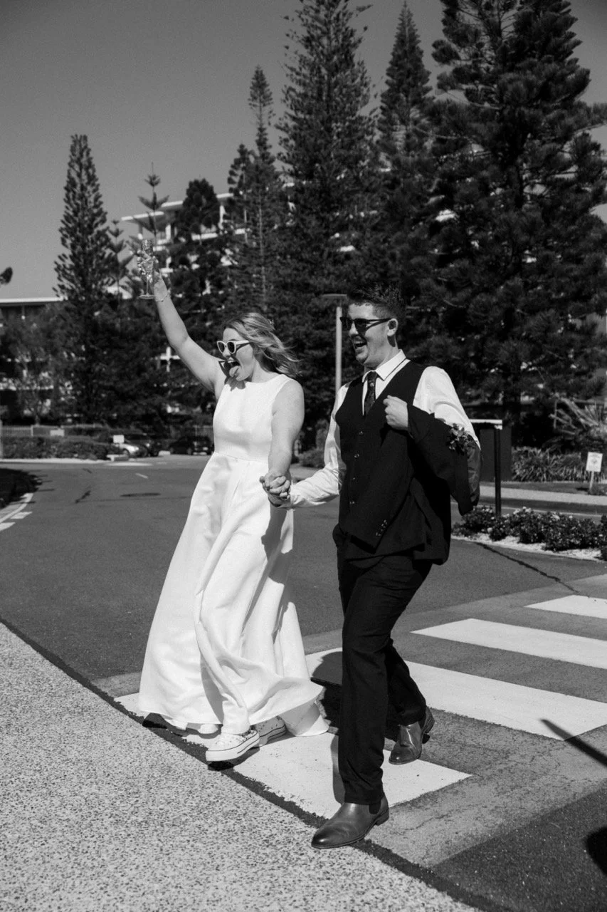 bride and groom walk across the street together