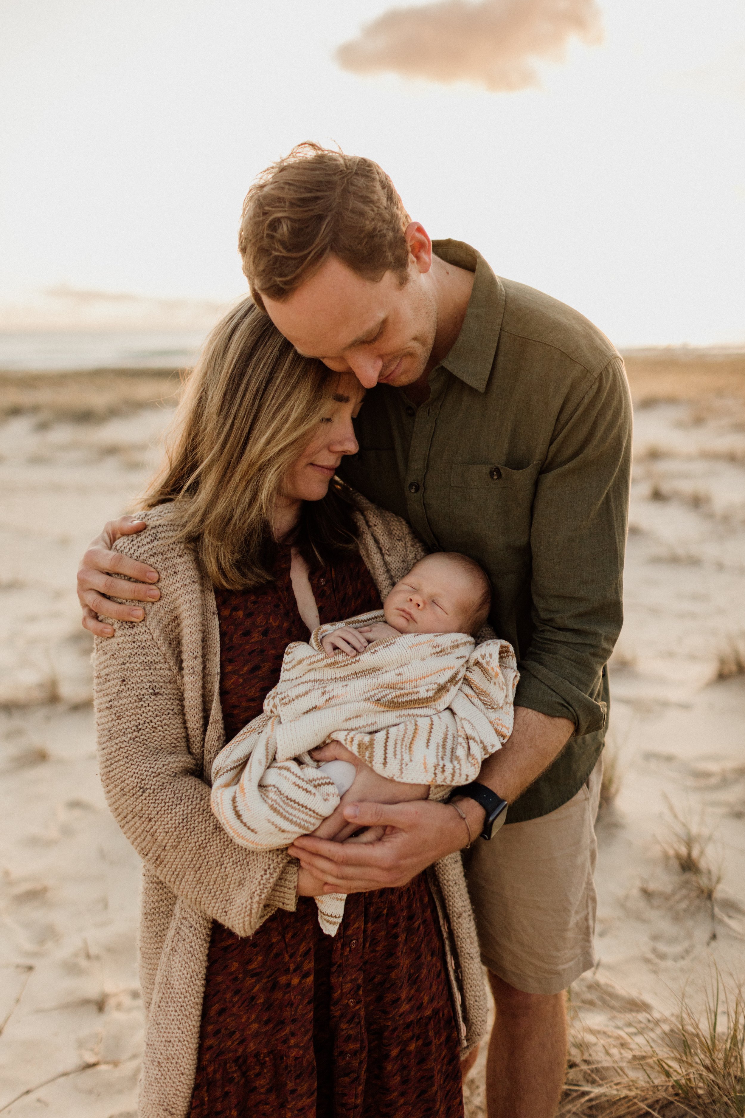 newborn baby with family on gold coast beach sunrise