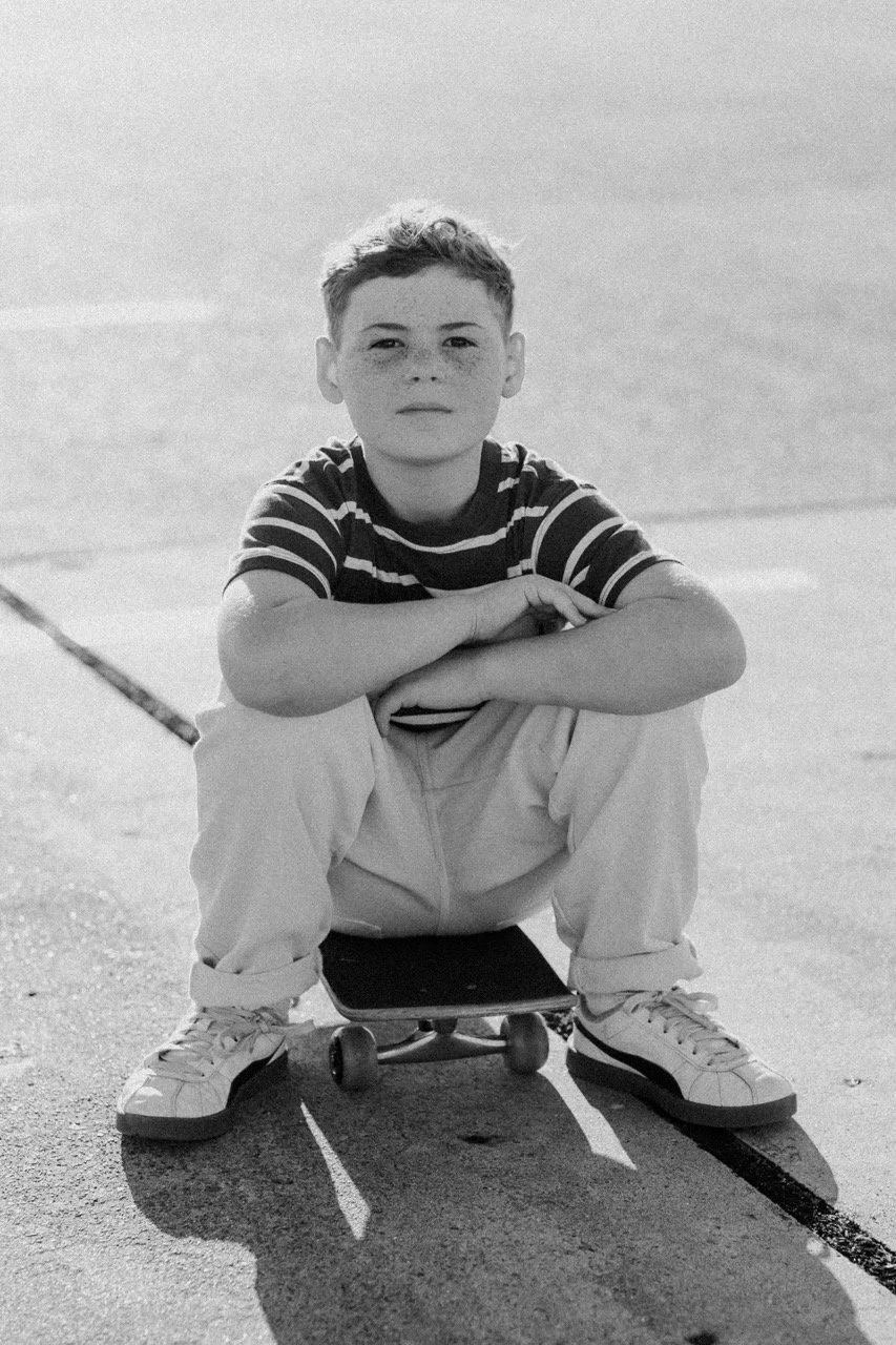 boy sits on skateboard family photoshoot
