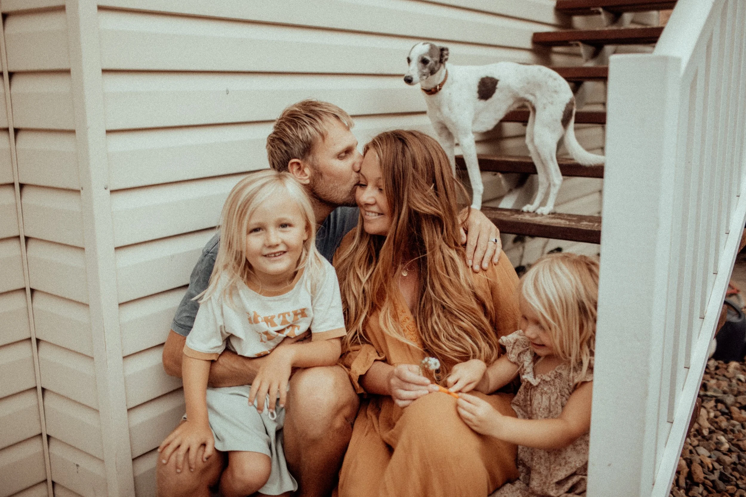 happy family with pet dog sitting on steps