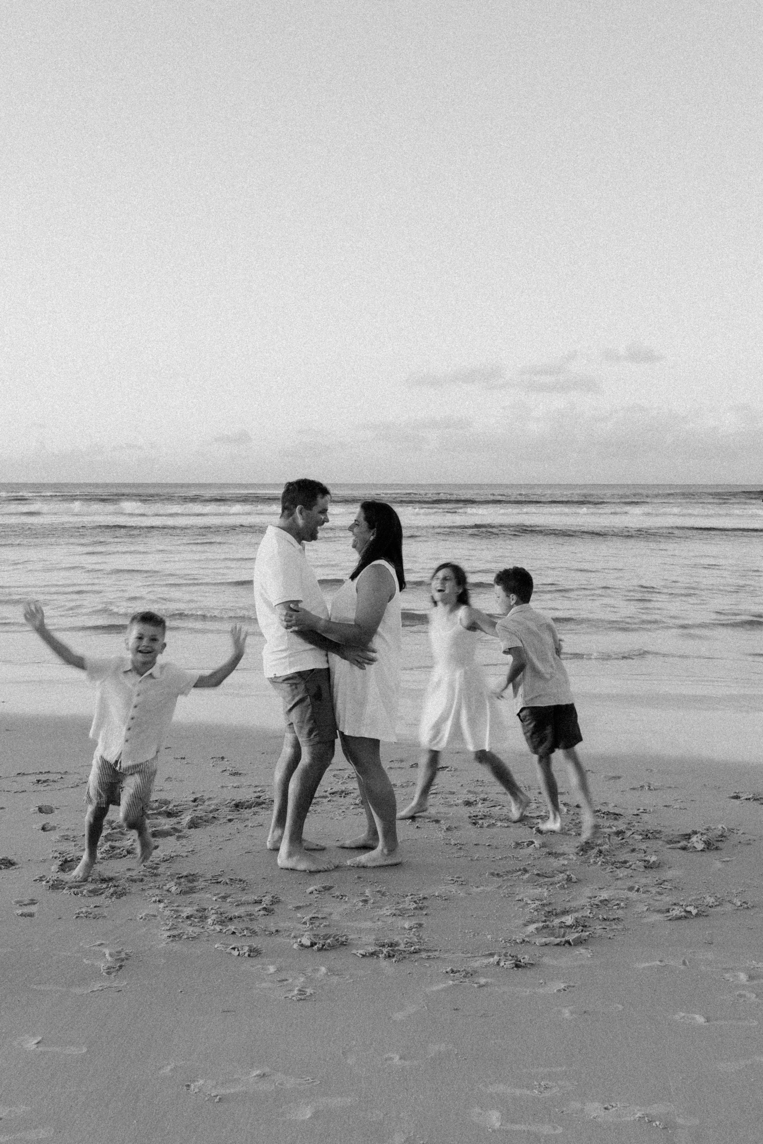 black and white family at beach crazy kids