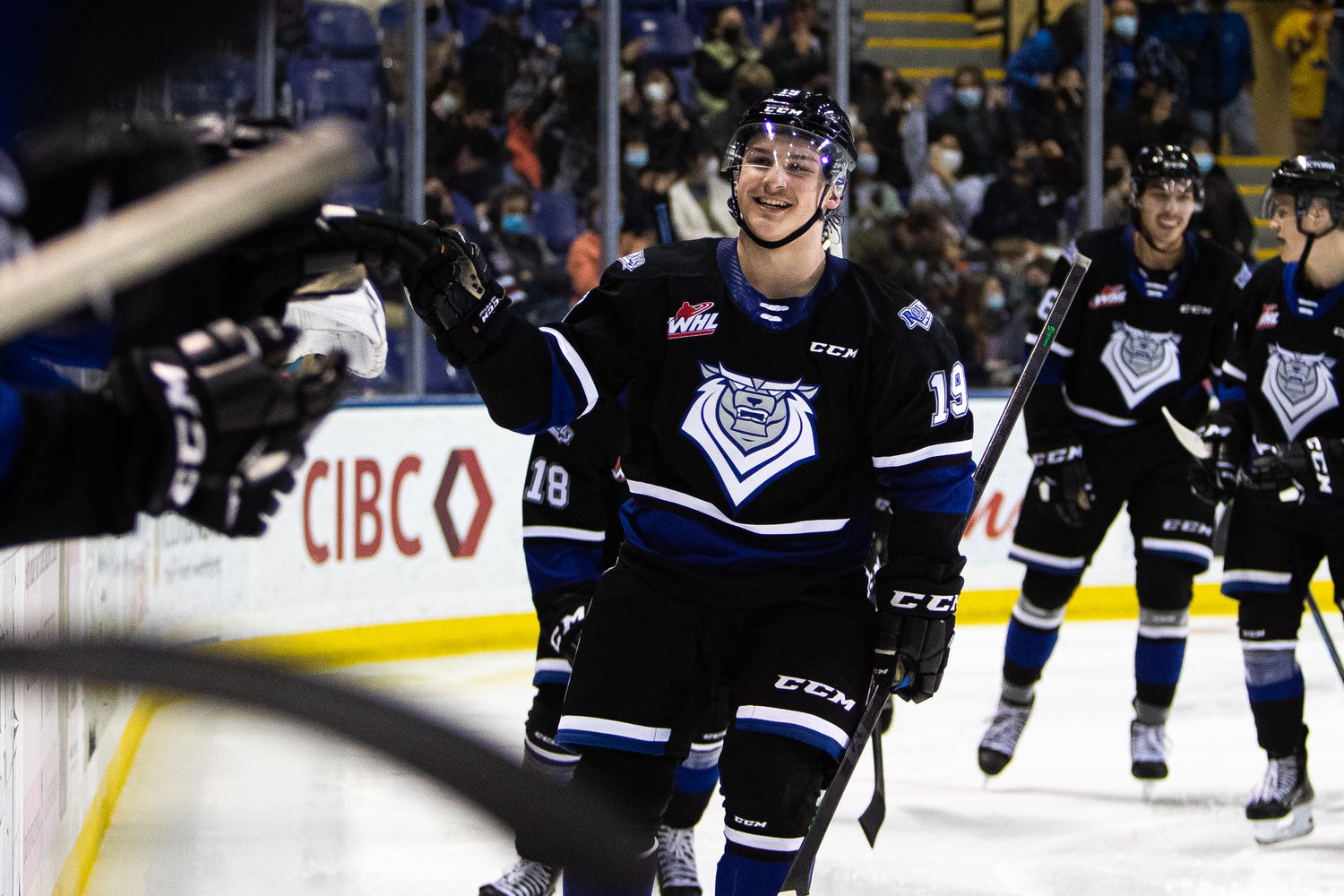 Brayden Schuurman of the Victoria Royals high fives his teammates after a goal
