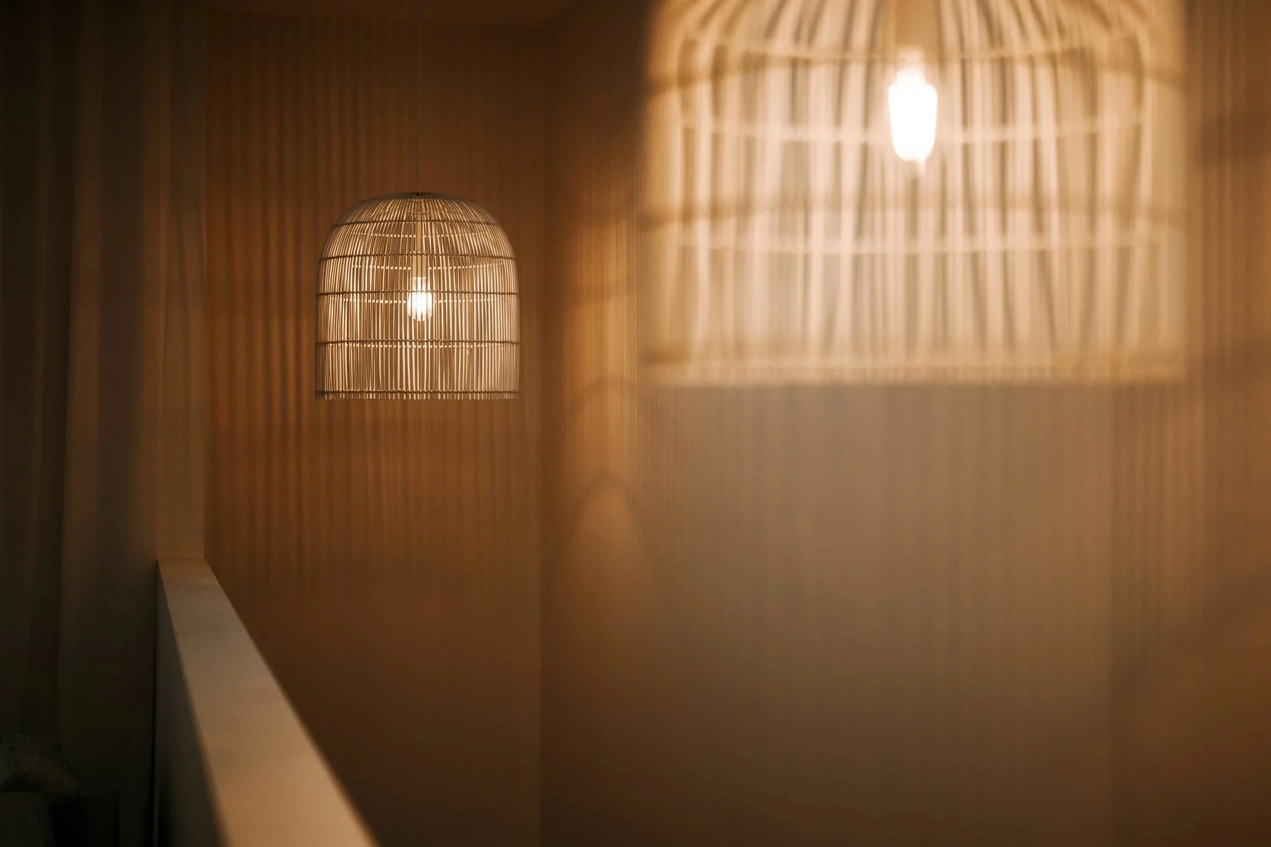 Warm stairwell detail with timber panelling and feature lighting in Cronulla duplex home
