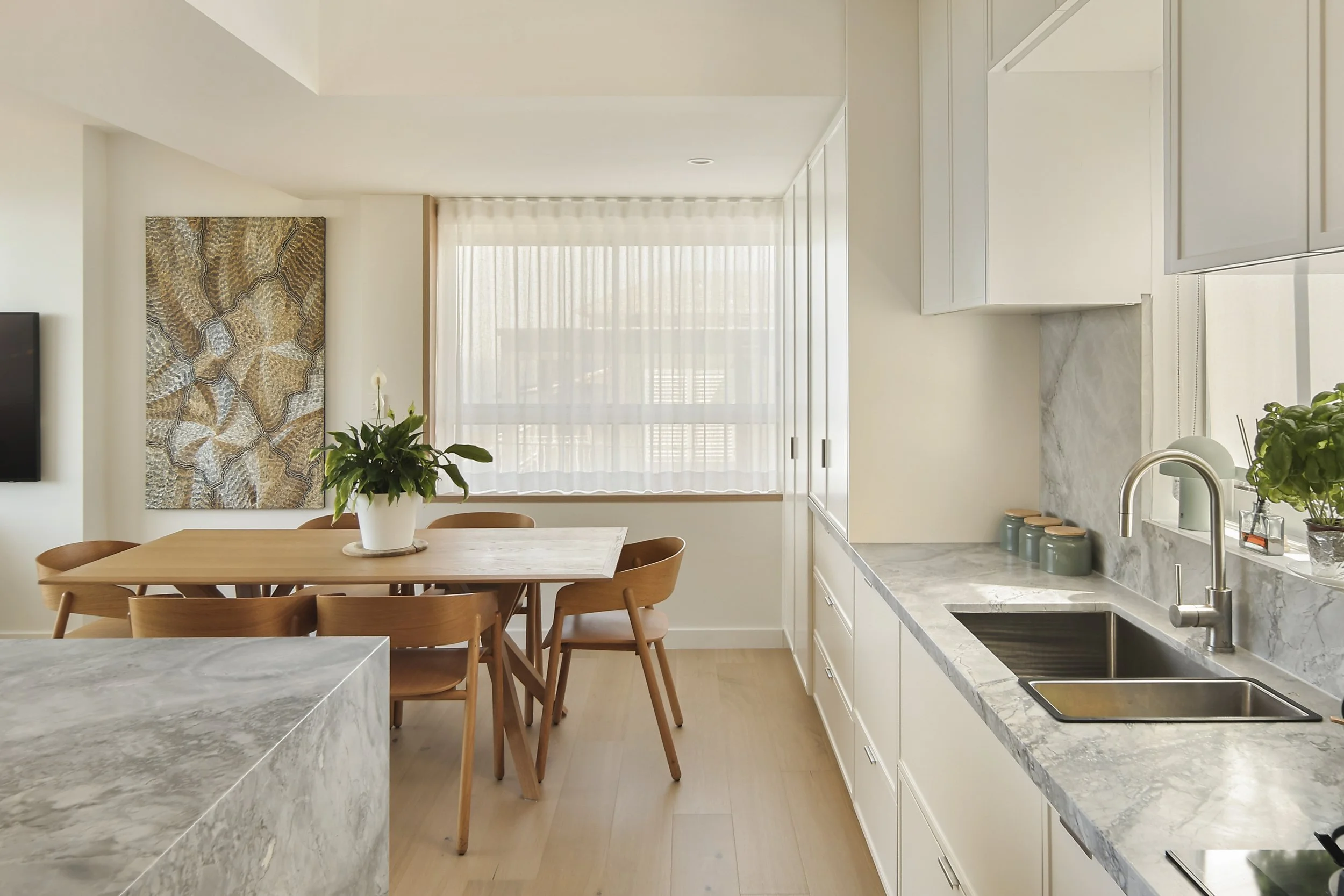 Open-plan kitchen and dining with marble island and full-height joinery