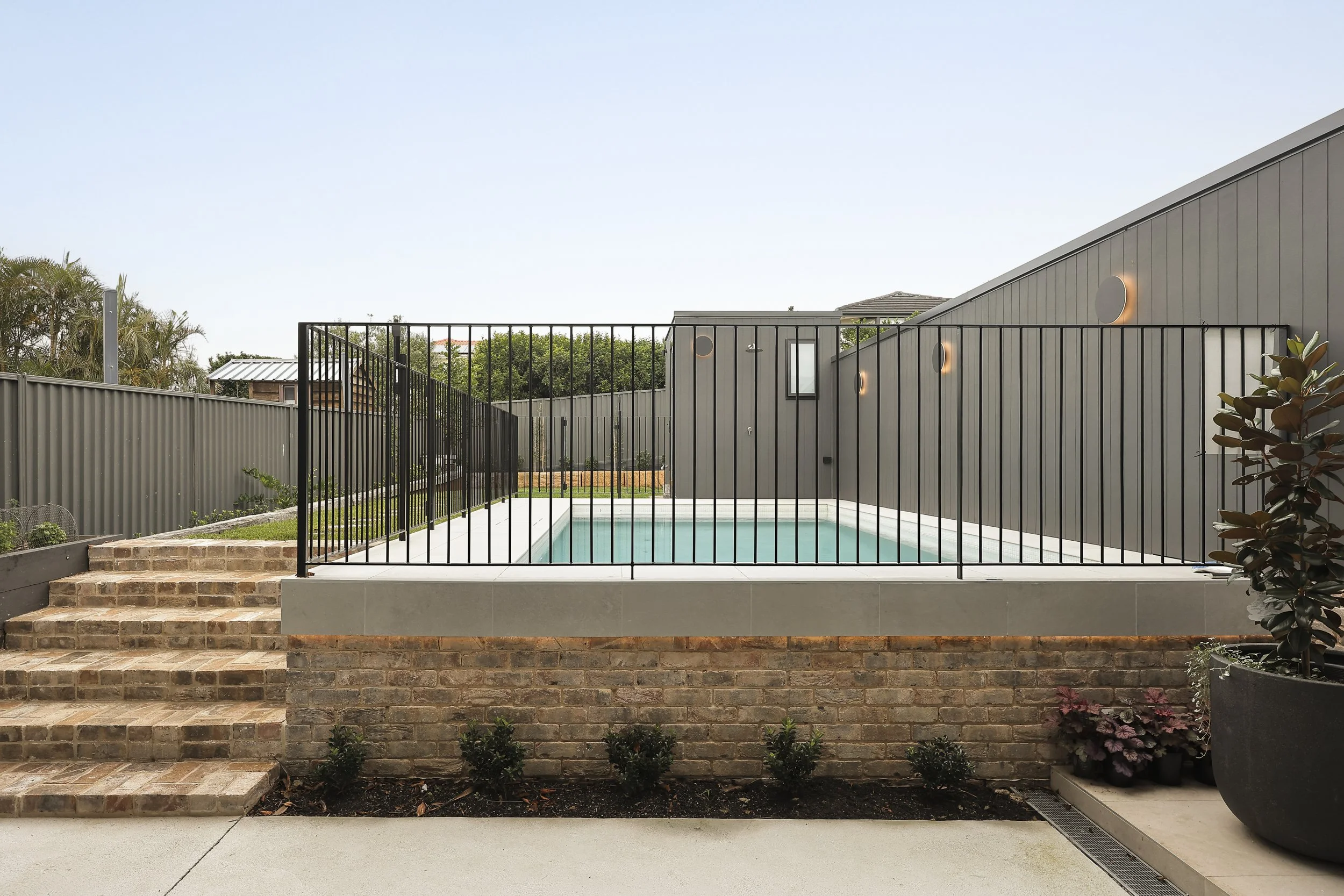 Rear garden with raised swimming pool terrace and brick retaining walls
