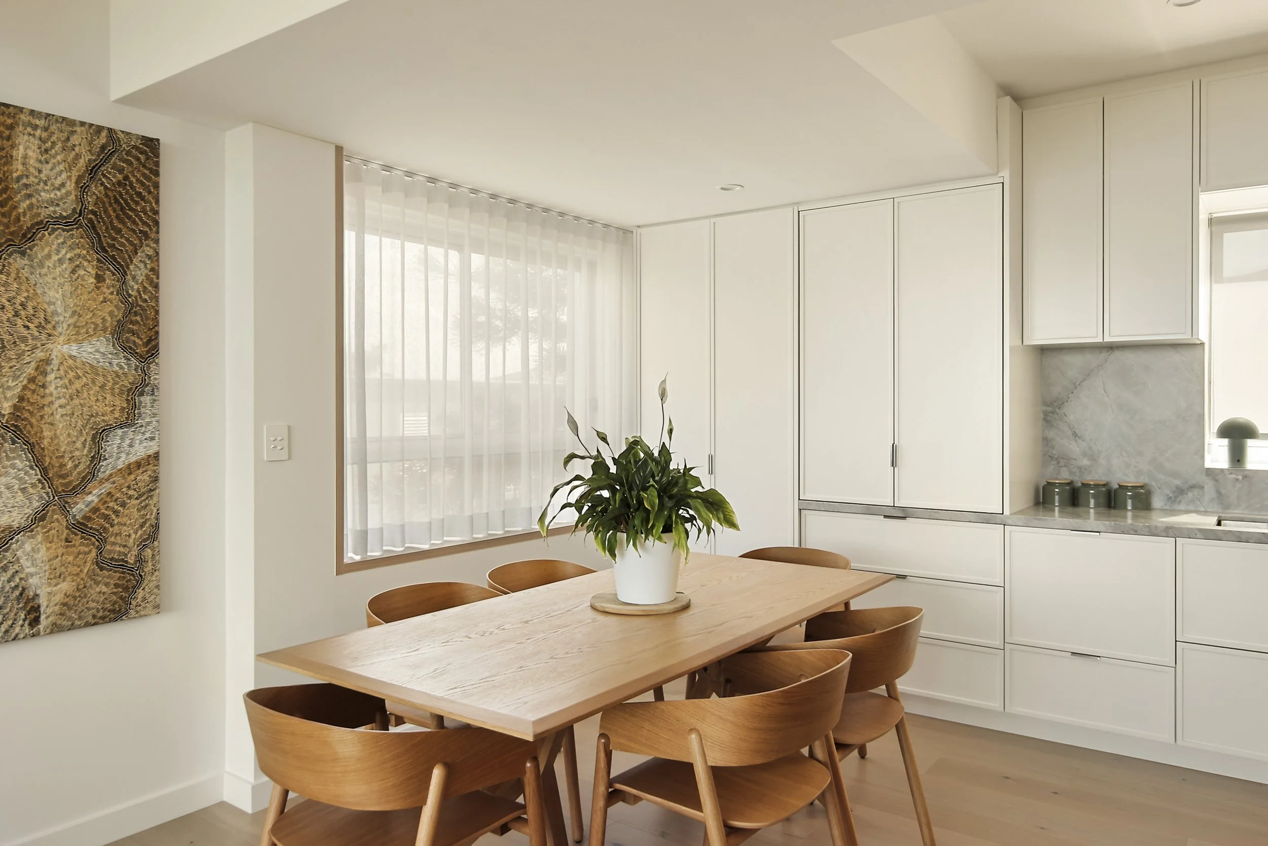 Dining and living area with stone island, timber floors and integrated lighting
