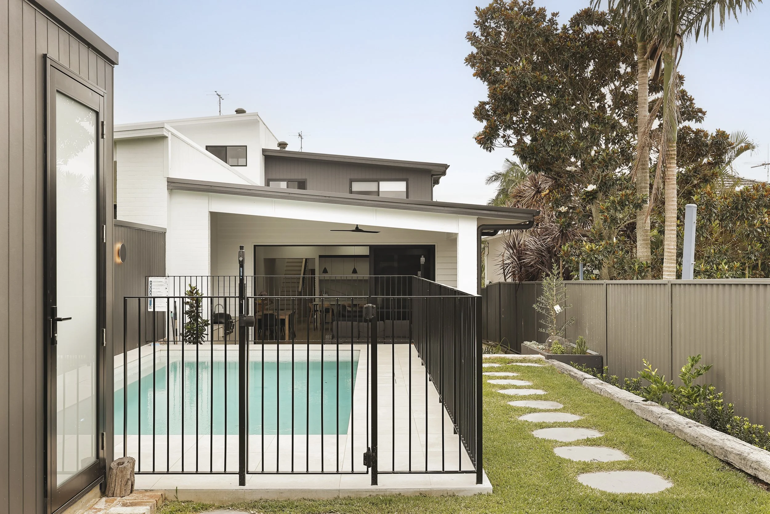 Swimming pool courtyard with contemporary pool house and vertical cladding