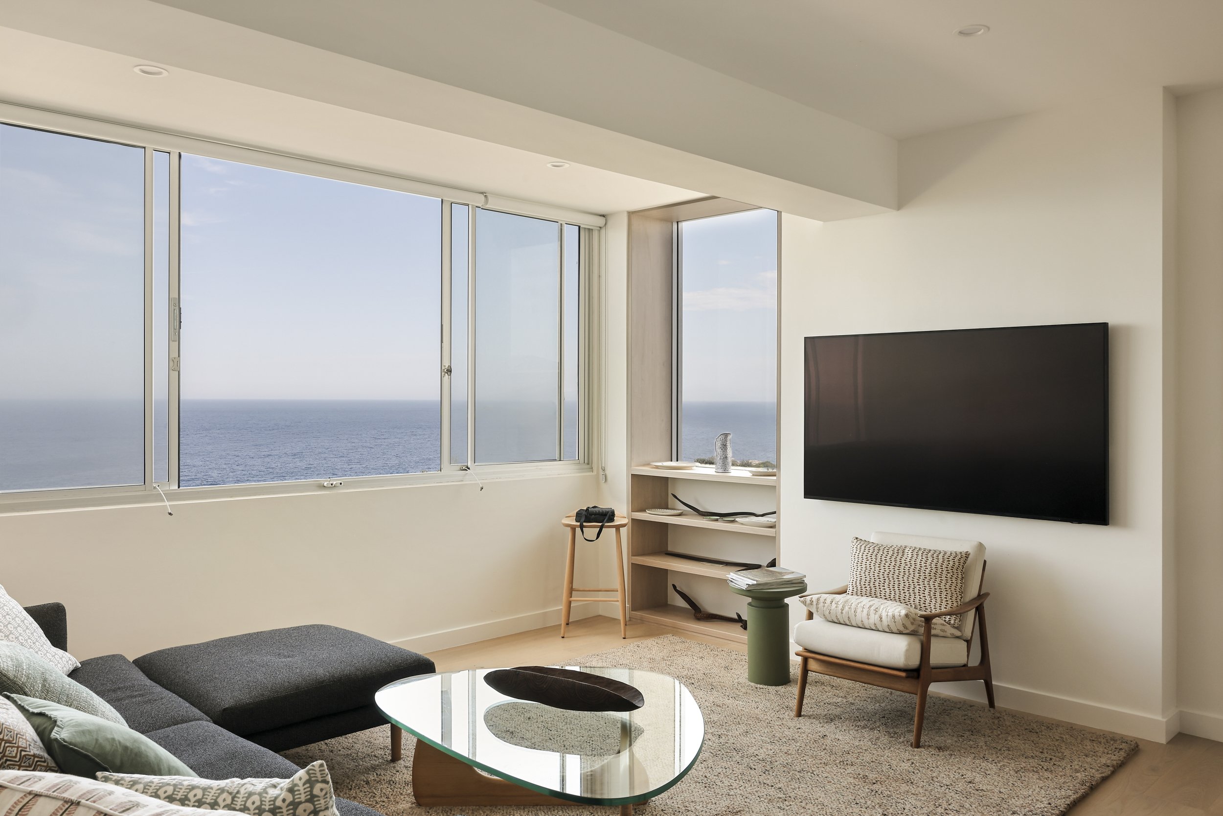 Bedroom with floor-to-ceiling joinery and coastal views through large window