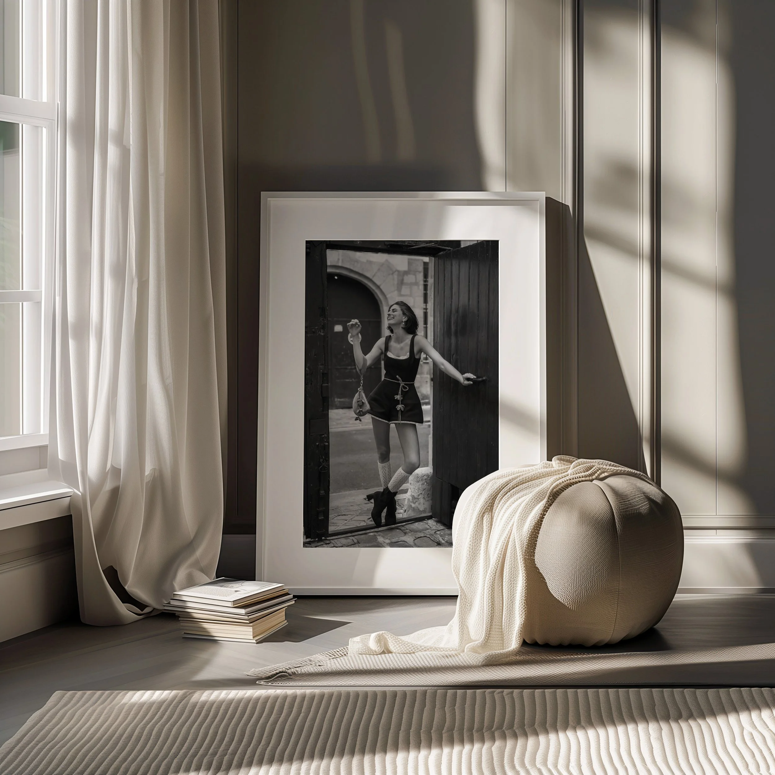 Ein schwarweißes Foto eines lachenden Mädchens, das in einem offenen Tor steht, gestylt in einem schwarzen Kleid mit hohen Schuhen und Socken.