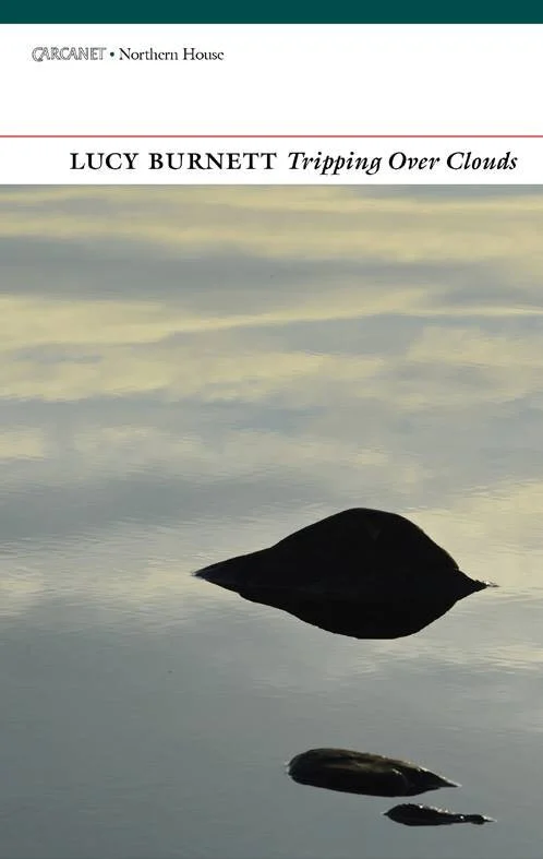 A book cover featuring a calm body of water with two dark rocks and a reflection of the sky with clouds, titled 'Tripping Over Clouds' by Lucy Burnett.