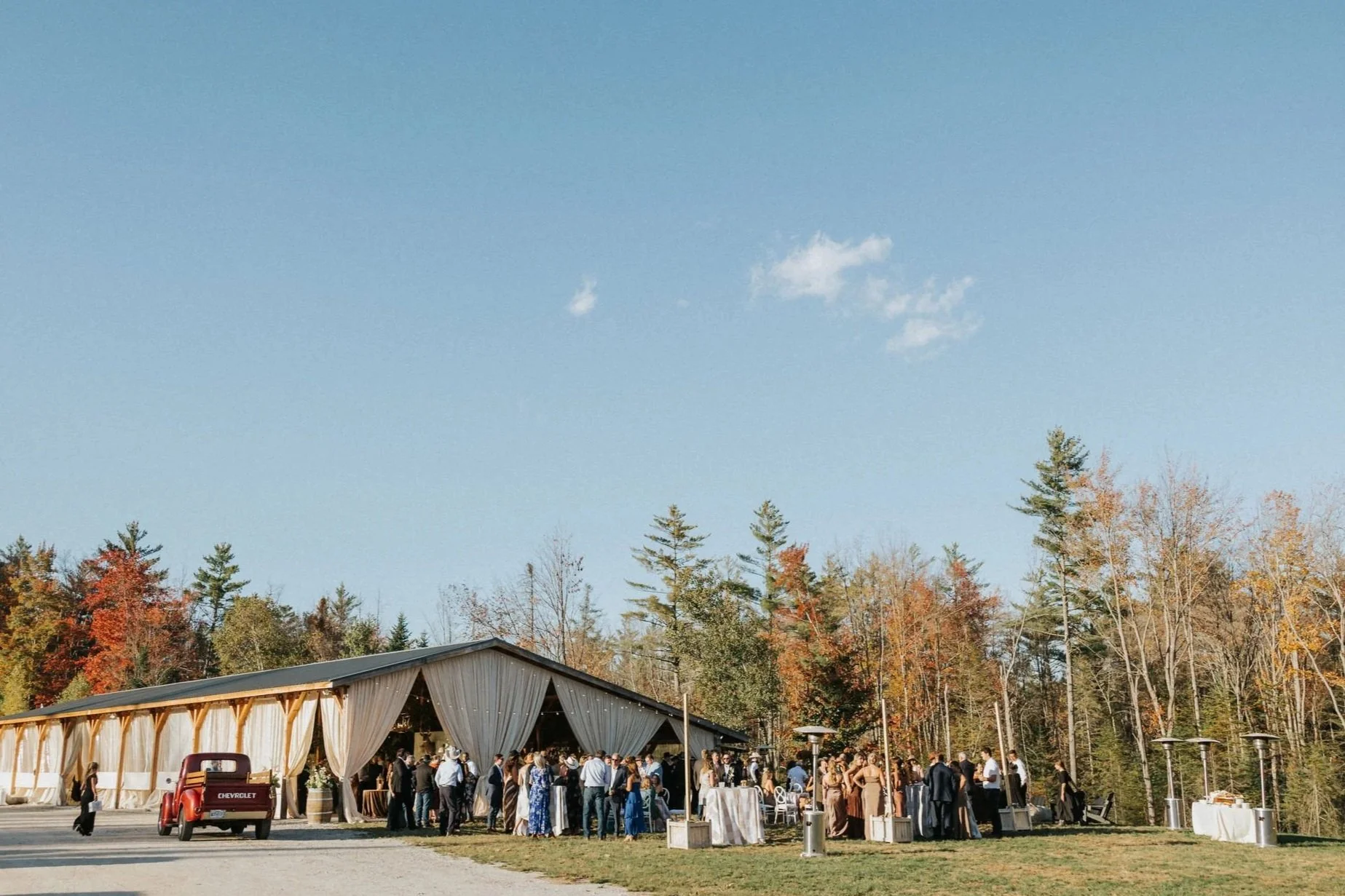 Wedding guests enjoying cocktail hour at rustic Bethel, Maine barn