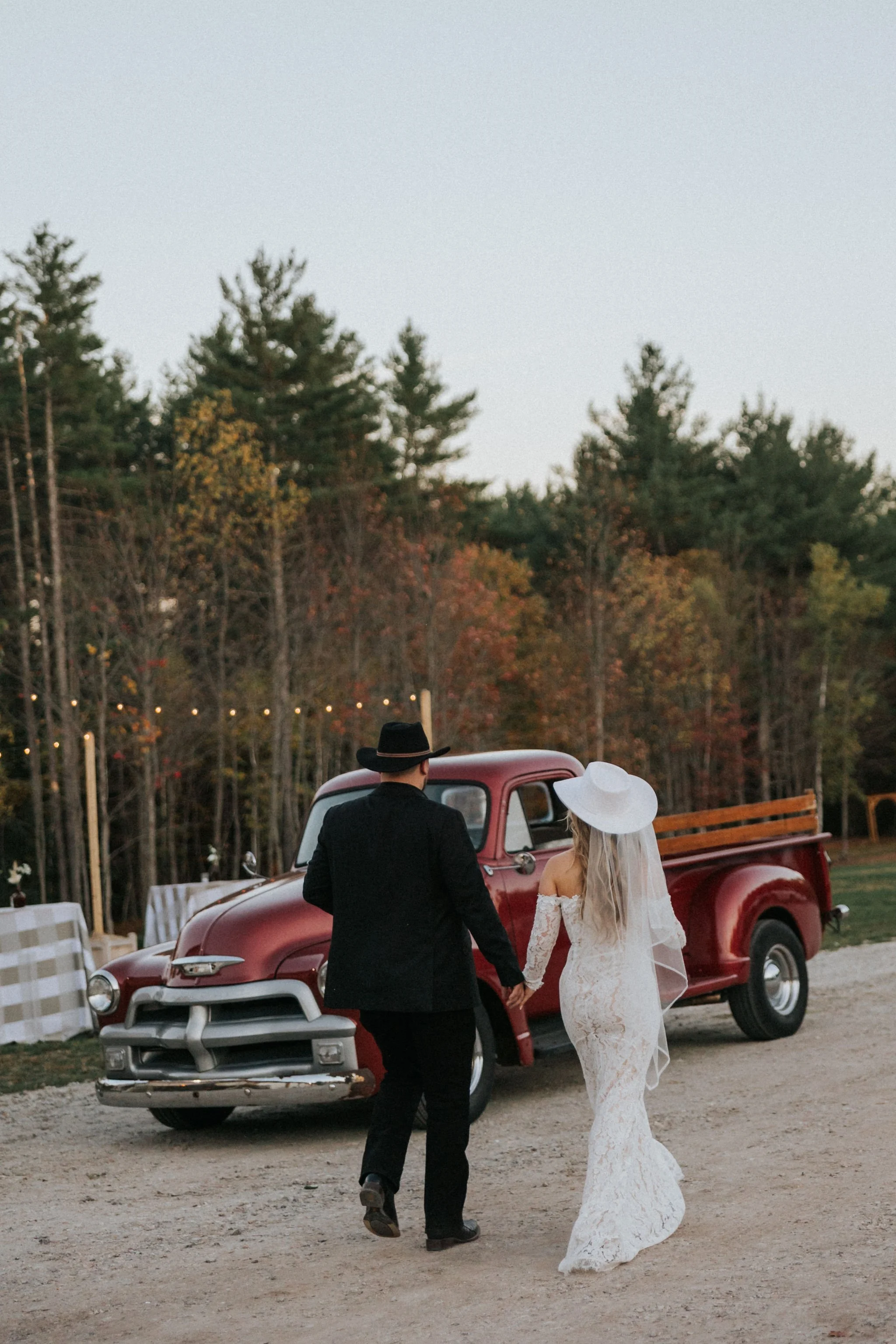 Maine Bride and Groom wearing cowboy hats and walking away hand in hand.