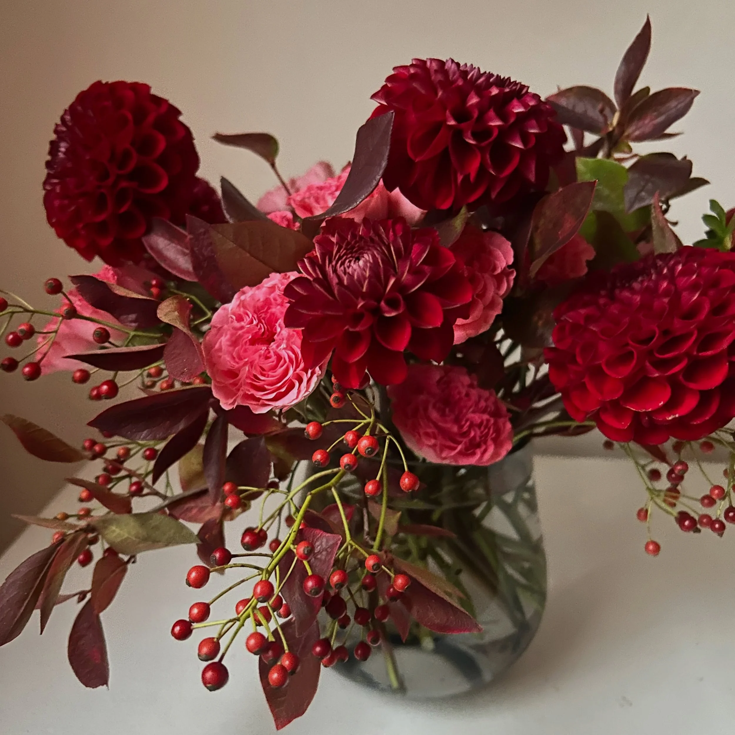 High bush blueberry branches from @rivard.farm with &lsquo;Cornel&rsquo; Dahlias from @bumblerootorganicfarm and rose hips from @broadturn_farm via @maineflowercollective with imported &lsquo;Wink Coral Kiss&rsquo; Spray Roses
