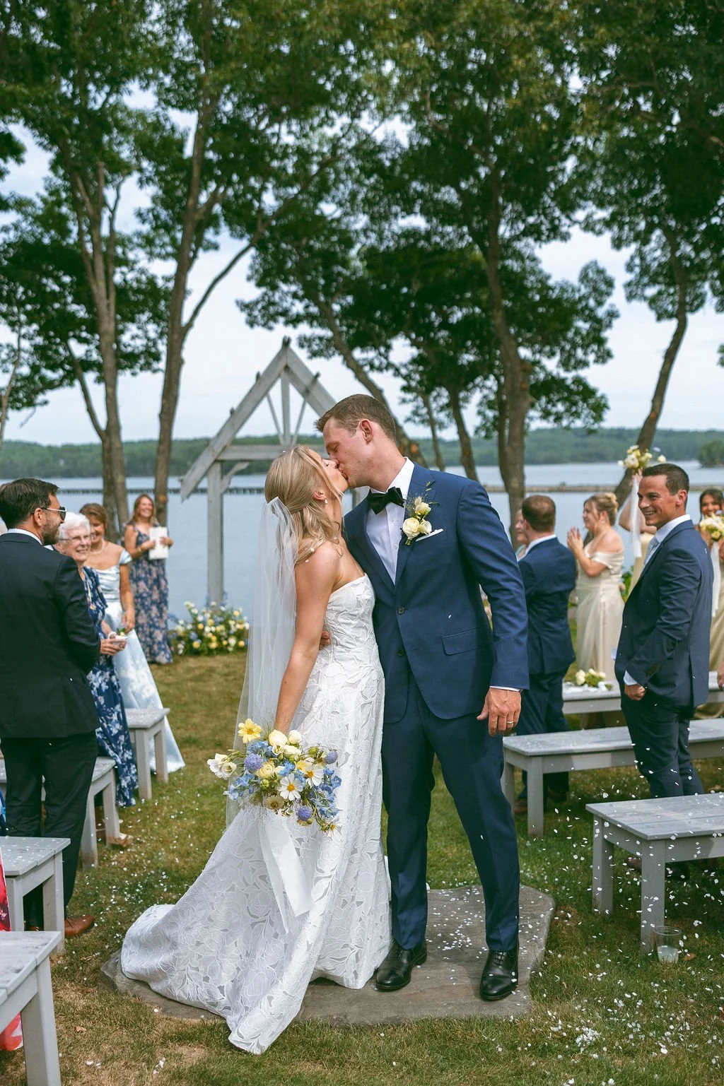 Bride and groom kiss at summer wedding in Maine