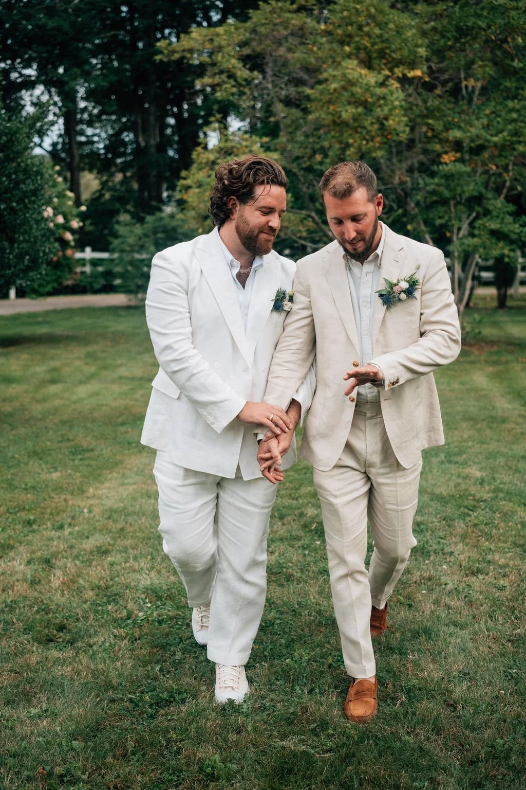Grooms walking hand in hand at Live Well Farm. Flowers by Harpswell, Maine Florist