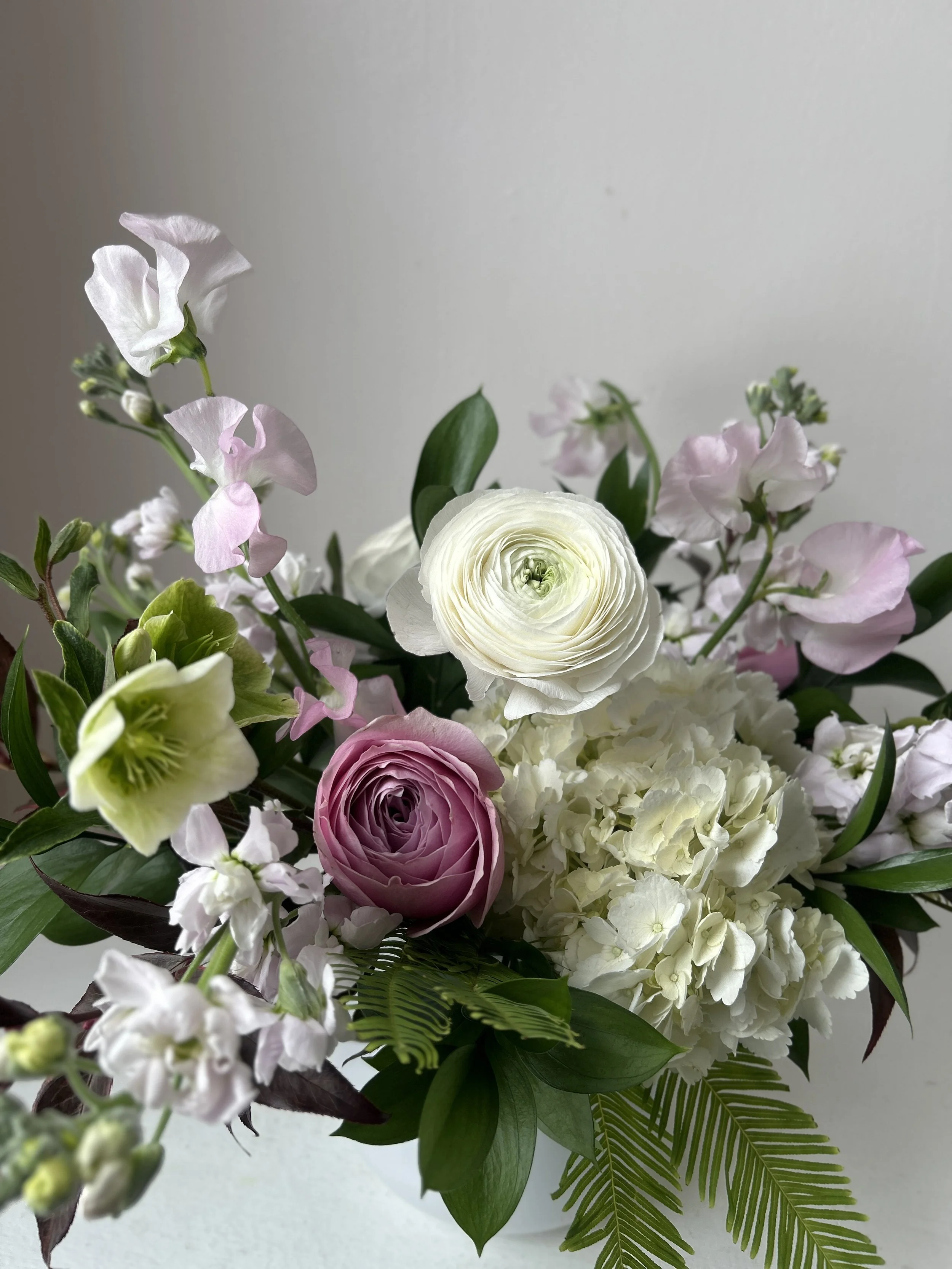 Romantic and elegant floral arrangement of pastel colored Sweet Peas, Garden Roses and Ranunculus by Harpswell, Maine florist Celadon Floral