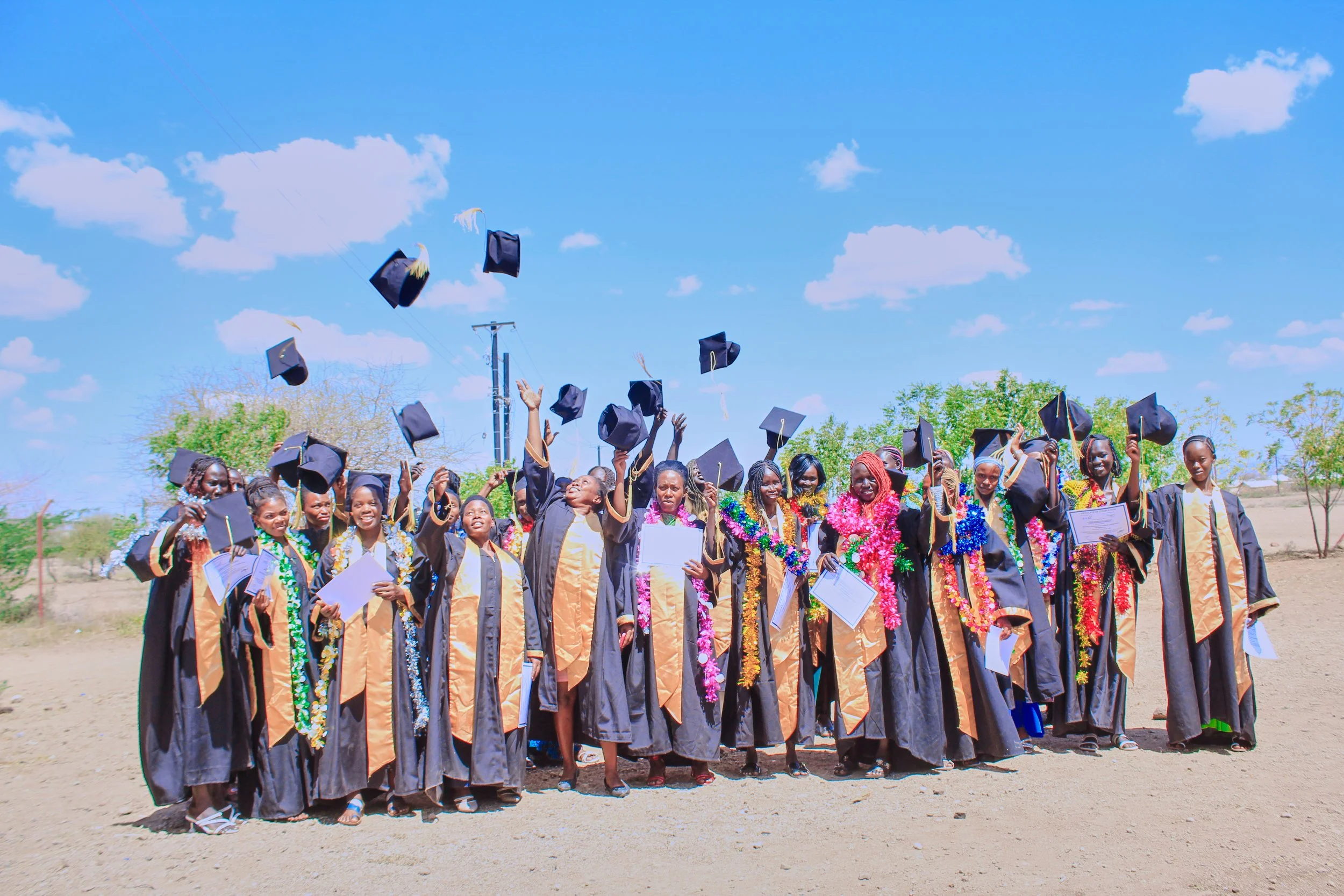 Women in graduation robes throwing mortar boards in the air