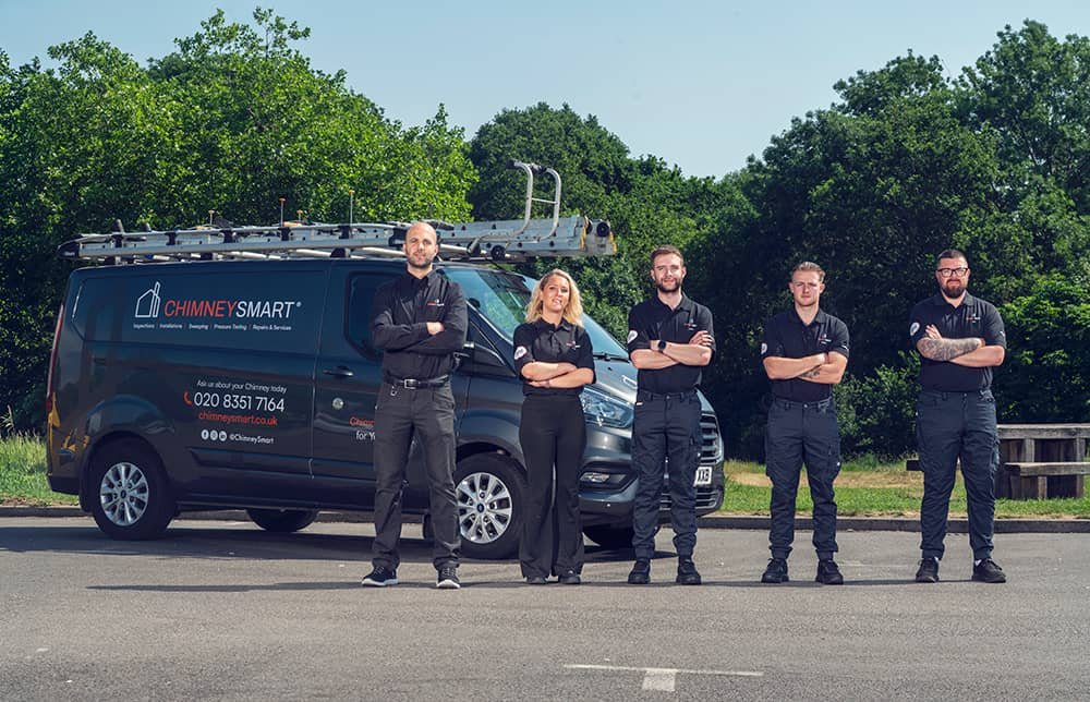 One and four installers of ChimneySmart company standing in front of branded van in North London