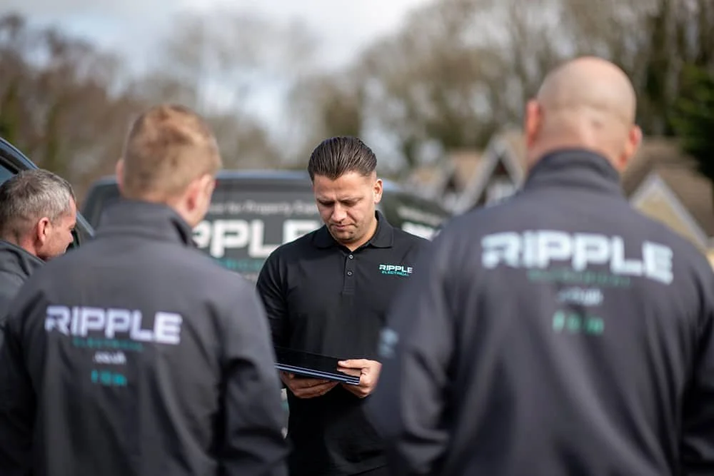 Director of Ripple Electrical company briefing engineers beside a branded company van before starting work in Sevenoaks, Kent